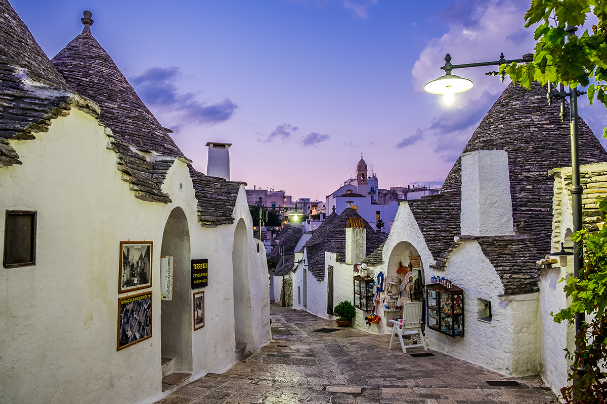 Traditionelle Trulli-Häuser in Alberobello (Süditalien) bei Dämmerung, passend zur Serata del Sud im Ristorante Mercato.